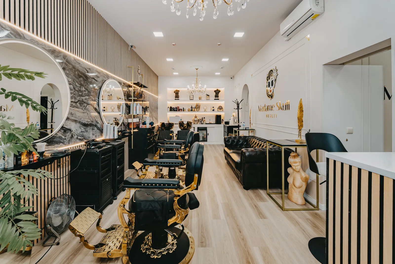 Sala da Madame Skull Beauty com espelhos redondos, bancada de produtos e cadeiras de styling