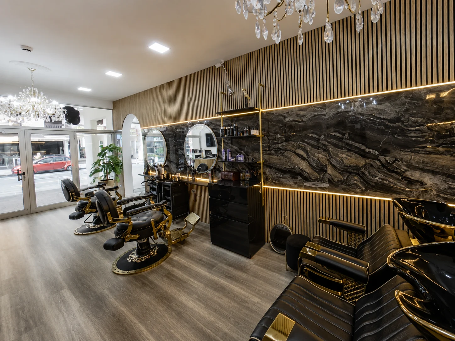 Sala de styling da Madame Skull Beauty com cadeiras, espelhos e iluminação dourada