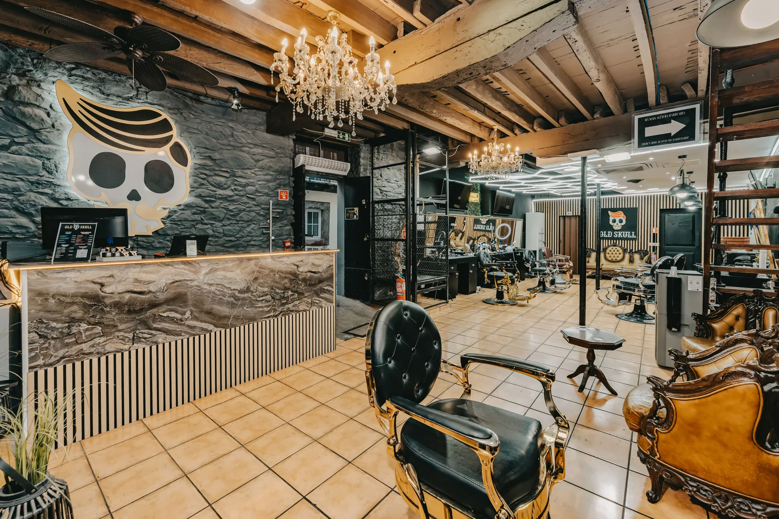 Reception area at Old Skull Rua dos Aranhas with chandeliers and barber chairs